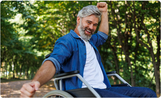 Happy man in wheelchair outdoors